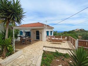 a house with a patio with a table and chairs at Green Olive House in Agios Nikolaos
