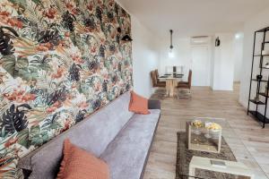 a living room with a couch and a floral wall at Moonkey - Apto L'aigüera A in Benidorm