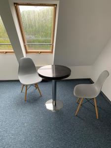 two chairs and a table in a room with a window at Pokoje Centrum in Sopot
