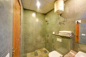 a bathroom with a shower and a toilet and a sink at Wood Rose Hotel Near Delhi Airport in New Delhi