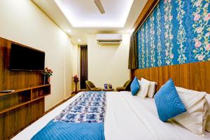 um quarto de hotel com uma cama e uma televisão em Wood Rose Hotel Near Delhi Airport em Nova Deli