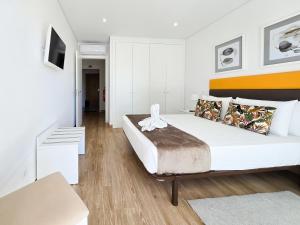 Un dormitorio con una gran cama blanca y un sofá. en Apartment Praia Rocha Residence Jade, en Portimão 28 fotos más