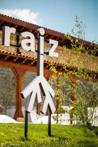 ein Metallschild im Gras vor einem Haus in der Unterkunft Hotel Raíz in Roa