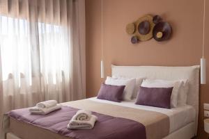a bedroom with towels on a bed with a window at Koukounaraki Apartment 1 in Skiathos Town