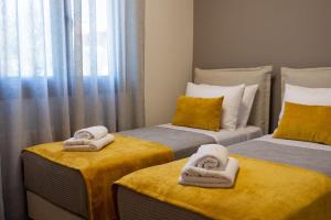 een kamer met 2 aparte bedden en handdoeken bij Koukounaraki Apartment 1 in Skiathos-stad