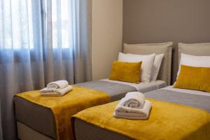 a room with two twin beds with towels on them at Koukounaraki Apartment 1 in Skiathos