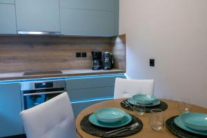 a kitchen with a wooden table with blue plates on it at Koukounaraki Apartment 1 in Skiathos