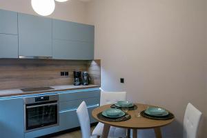 a kitchen with a table and chairs and a kitchen with a counter at Koukounaraki Apartment 1 in Skiathos
