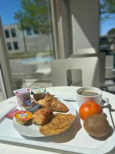 - un plateau de petit-déjeuner avec une tasse de café et des viennoiseries dans l'établissement Premiere Classe Toulouse Sud Labege, à Labège