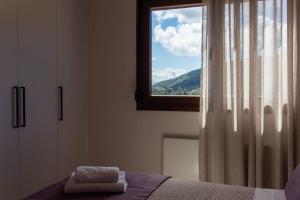 a bedroom with a window with a towel on a bed at Koukounaraki Apartment 1 in Skiathos