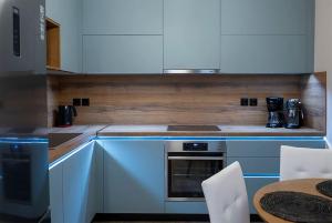 a kitchen with white cabinets and a stove top oven at Koukounaraki Apartment 1 in Skiathos