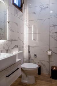 a white bathroom with a toilet and a sink at Koukounaraki Apartment 1 in Skiathos