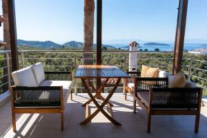 a patio with a table and chairs on a balcony at Koukounaraki Apartment 1 in Skiathos