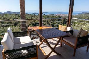a patio with a table and chairs on a balcony at Koukounaraki Apartment 1 in Skiathos