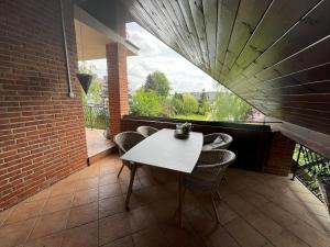カジミエシュ・ドルニにあるPokoje gościnne u Dorotyの白いテーブルと椅子、窓のあるバルコニー