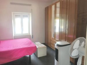 Un pequeño dormitorio con una cama rosa y una ventana en 2 bedrooms apartement with enclosed garden and wifi at Cioccatelli 1 km away from the beach, en Cerreto Alto