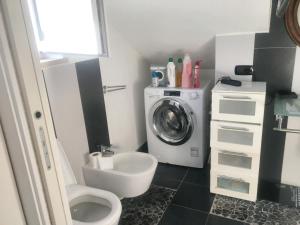 y baño con aseo y lavadora. en 2 bedrooms apartement with enclosed garden and wifi at Cioccatelli 1 km away from the beach, en Cerreto Alto
