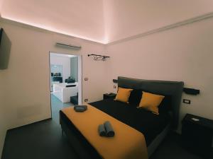 a bedroom with a bed with yellow pillows and a mirror at Le Suite di Magda Relax & Rooms in Polignano a Mare