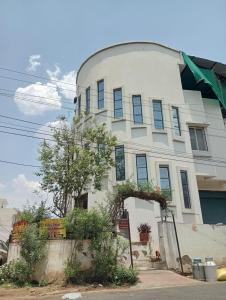 a white building with blue windows on a street at Paarijat PG in Udaipur