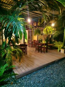 um pátio com mesas e cadeiras e uma palmeira em Caribbean Sea Towers Hotel em Puerto Viejo