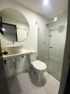 a bathroom with a toilet and a sink and a mirror at 33 Hotel Bulerias in Medellín +83 photos