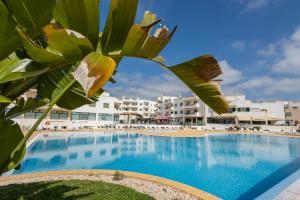 a large swimming pool with buildings in the background at Dunas do Alvor - Torralvor in Alvor
