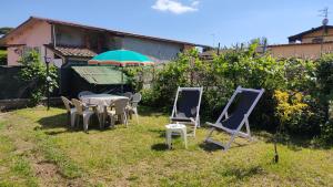 a table and chairs and an umbrella in a yard at Casa Perla vicino al mare in Massa
