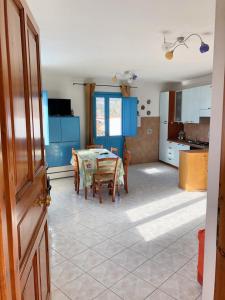 a kitchen and dining room with a table and chairs at 2 bedrooms apartement at Lotzorai 800 m away from the beach with furnished balcony in Lotzorai