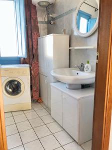 a bathroom with a sink and a washing machine at 2 bedrooms apartement at Lotzorai 800 m away from the beach with furnished balcony in Lotzorai