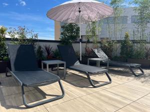 格拉納達的住宿－Apartamentos Luna Suites Granada，庭院里摆放着一对椅子和一把遮阳伞