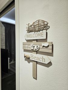 uma placa que diz bem-vindo à praia numa porta em Casa Mavira House em Rimini