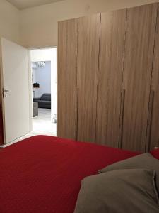 um quarto com uma cama vermelha e armários de madeira em Casa Mavira House em Rimini