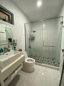 a bathroom with a shower and a toilet and a sink at Mimi Homestay in Liên Trì (3)