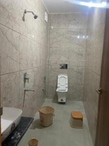 a bathroom with a shower with a toilet and a sink at Pavan Guest Inn in Vrindāvan