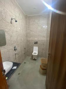 a bathroom with a toilet and a sink at Pavan Guest Inn in Vrindāvan