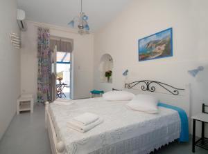 ein weißes Schlafzimmer mit einem Bett mit Handtüchern darauf in der Unterkunft Filio rooms in Kýthira