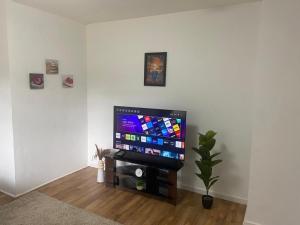 sala de estar con TV de pantalla plana en la pared en Entire home in Rednal United Kingdom, en Birmingham