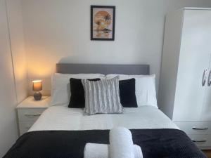 1 dormitorio con 1 cama grande con sábanas y almohadas blancas en Entire home in Rednal United Kingdom, en Birmingham