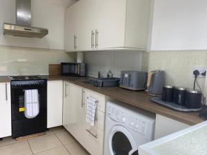 cocina con lavadora y lavadora en Entire home in Rednal United Kingdom, en Birmingham