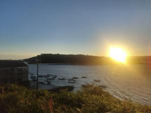 a sunset over a body of water with boats at El nido de lu in Vilagarcia de Arousa