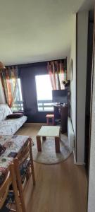 a room with a bed and a table in it at Appartement montagne in Superbagnères