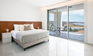 ein weißes Schlafzimmer mit Bett und Balkon in der Unterkunft Phaedrus Living Luxury Seaview Coral Bay Villa in Peyia + 22 Fotos