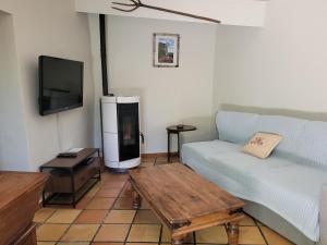 a living room with a couch and a tv at La tour de guet Maison atypique in Castellane