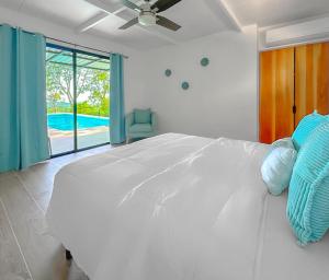 1 dormitorio con 1 cama blanca grande y piscina en Modern Home with Panoramic Ocean View and Pool, en Ojochal