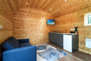 a living room with wooden walls and a blue couch at The Lodge at The Outside Inn in Mountfield