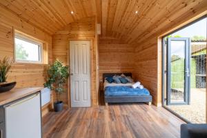 1 dormitorio en una cabaña de madera con 1 cama. en The Lodge at The Outside Inn, en Mountfield
