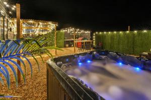 un parque acuático por la noche con luces azules en The Lodge at The Outside Inn, en Mountfield