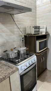 uma cozinha com um fogão e um micro-ondas em Espaço Zen em Cascavel