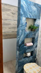 uma casa de banho com uma parede de plástico azul e um WC em Espaço Zen em Cascavel