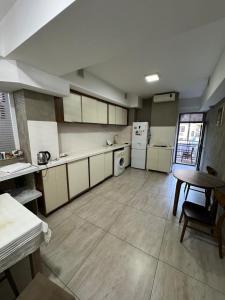 a large kitchen with white appliances and a table at Гостиница Низами Стрит in Baku